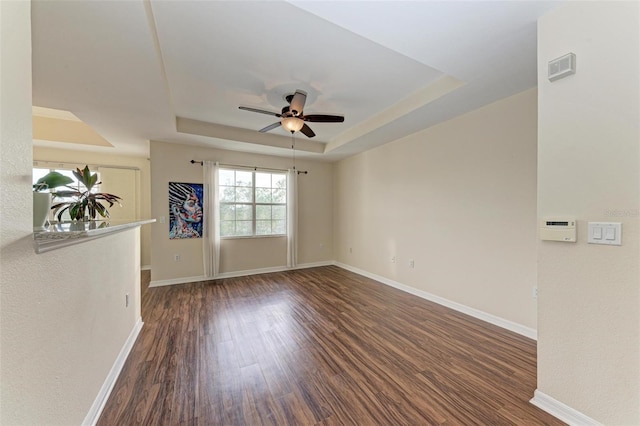 1195 Villagio Cir Unit 201, Sarasota, FL 34237 - spare room with a raised ceiling, a ceiling fan, wood finished floors, and baseboards