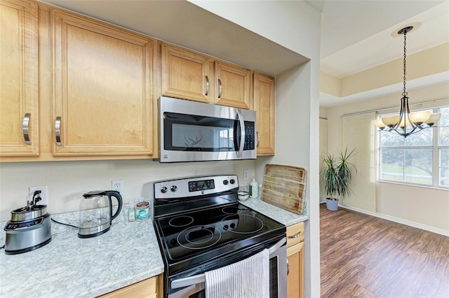 kitchen with light brown cabinetry, dark wood-type flooring, a notable chandelier, and appliances with stainless steel finishes