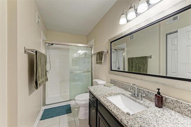 bathroom featuring tile patterned flooring, vanity, toilet, and walk in shower