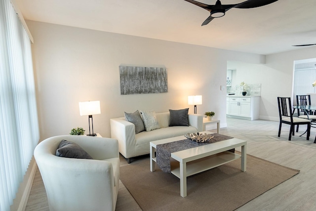 living room featuring ceiling fan and light hardwood / wood-style flooring