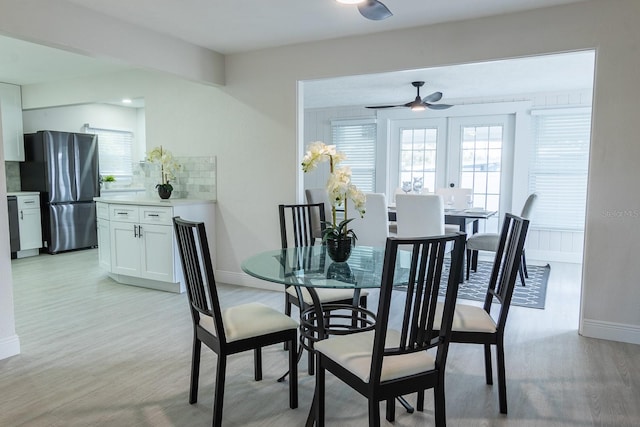 dining room with ceiling fan, french doors, and light wood-type flooring