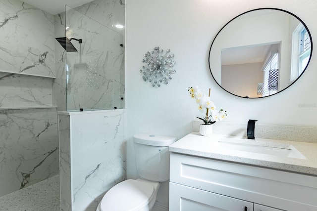 bathroom with vanity, toilet, and tiled shower