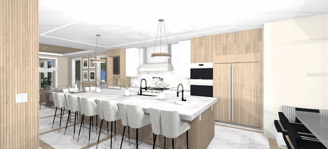 kitchen featuring a breakfast bar, sink, hanging light fixtures, light stone countertops, and an island with sink