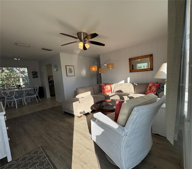 living room featuring dark wood-type flooring and ceiling fan