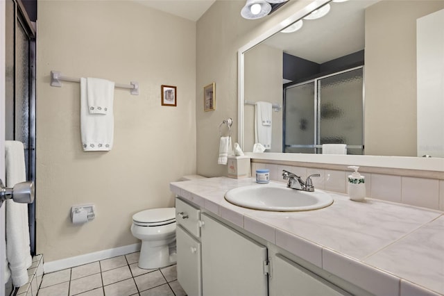 bathroom featuring tile patterned flooring, vanity, toilet, and a shower with shower door