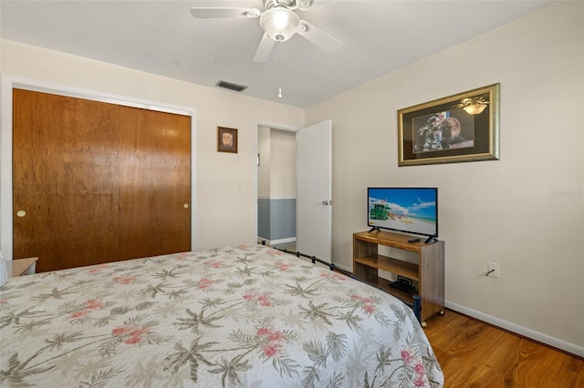 bedroom with ceiling fan, a closet, and hardwood / wood-style flooring