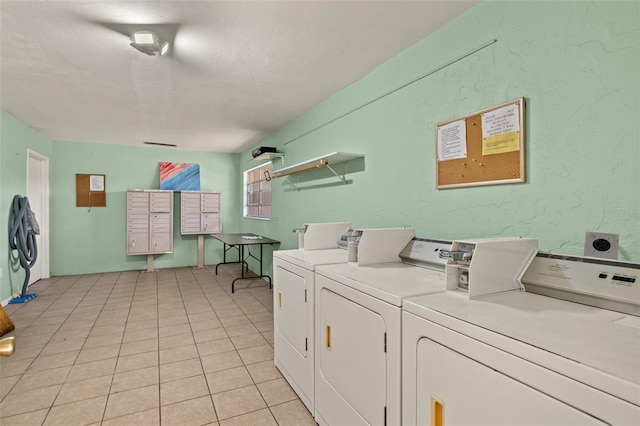 laundry room with washer and clothes dryer and light tile patterned floors