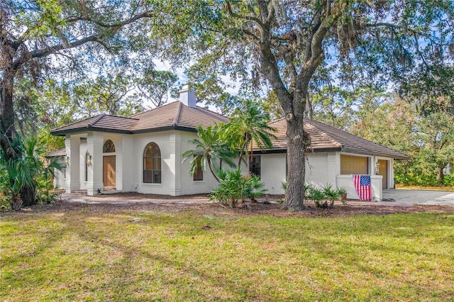 view of front of house featuring a garage and a front lawn