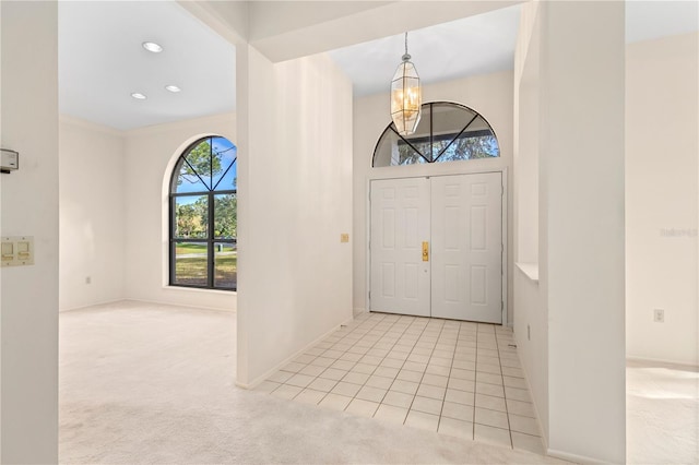 carpeted foyer featuring a notable chandelier