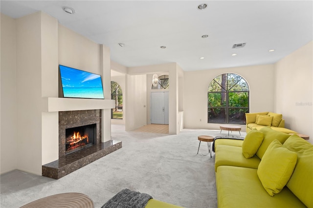 carpeted living room featuring a premium fireplace