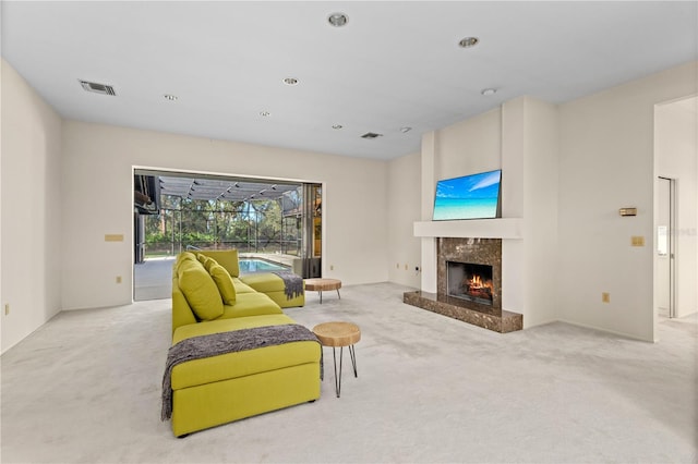 sitting room with light colored carpet and a fireplace