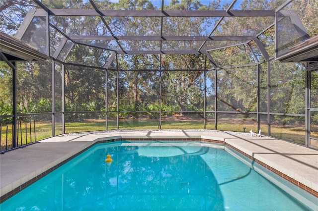 view of swimming pool featuring glass enclosure and a patio