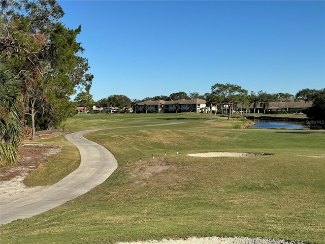 surrounding community with a lawn and a water view