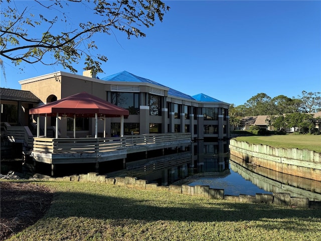 back of property with a gazebo, a yard, and a deck