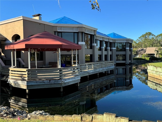 back of house with a gazebo and a water view