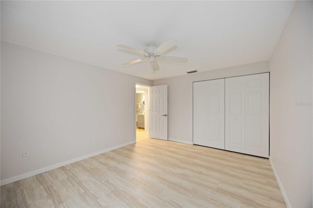 unfurnished bedroom featuring ceiling fan, a closet, and light hardwood / wood-style flooring