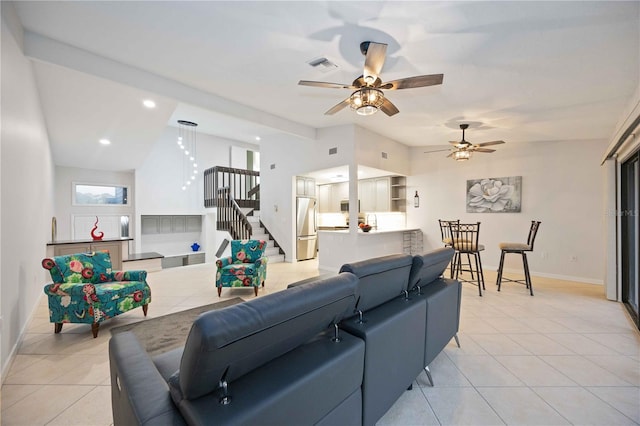 living room with ceiling fan, light tile patterned flooring, and vaulted ceiling