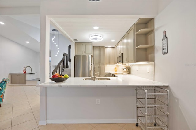 kitchen with a breakfast bar, sink, light tile patterned flooring, kitchen peninsula, and stainless steel appliances