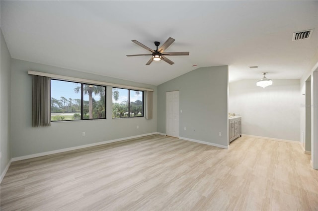 spare room with ceiling fan, light wood-type flooring, and vaulted ceiling