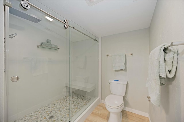 bathroom featuring toilet, wood-type flooring, and walk in shower