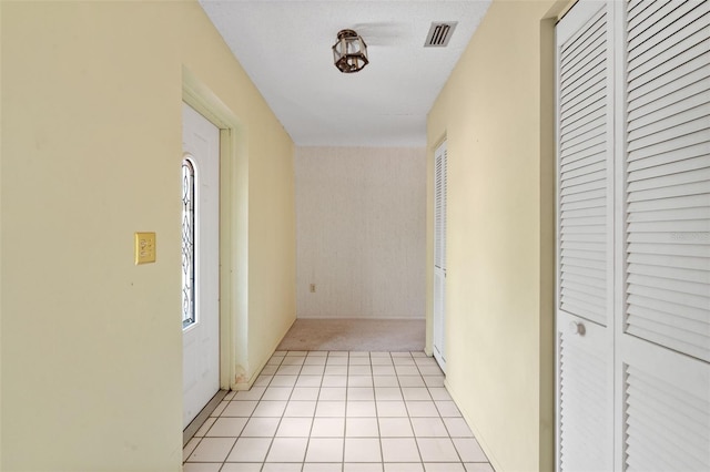 corridor featuring light tile patterned floors and a textured ceiling