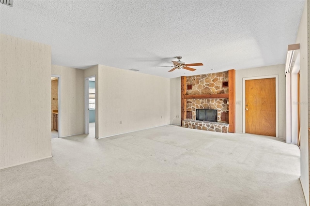 unfurnished living room with a fireplace, light carpet, a textured ceiling, and ceiling fan