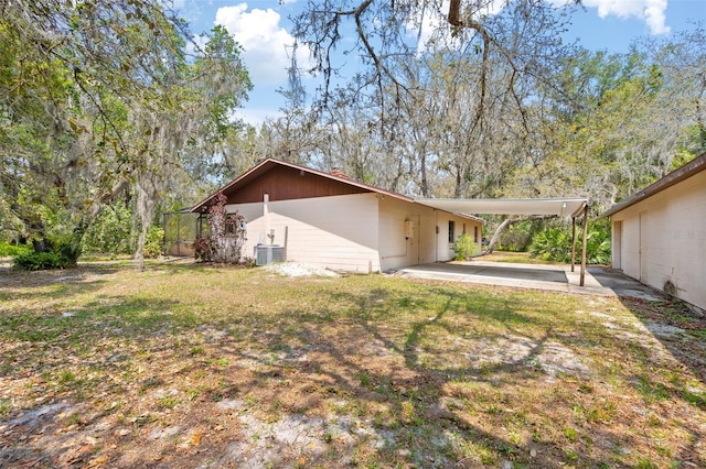 2807 Country River Dr, Parrish, FL 34219 - back of house with central AC, an attached carport, and a lawn