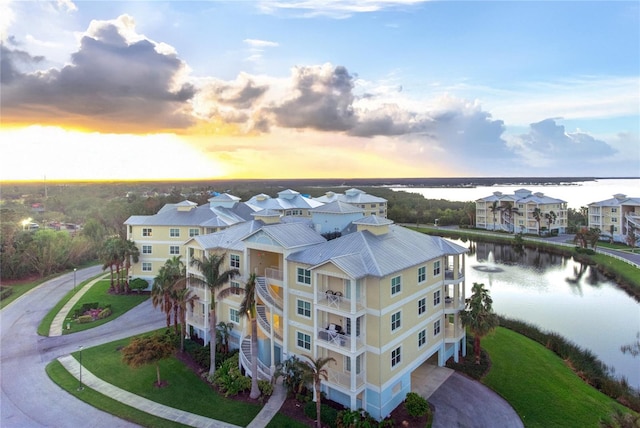 aerial view at dusk featuring a water view