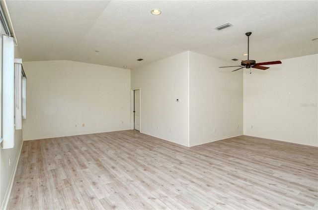 unfurnished room with a textured ceiling, light wood-type flooring, vaulted ceiling, and ceiling fan