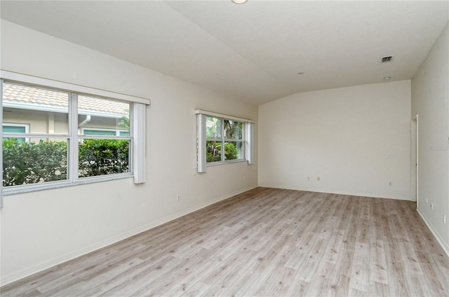 unfurnished room with light hardwood / wood-style flooring and vaulted ceiling