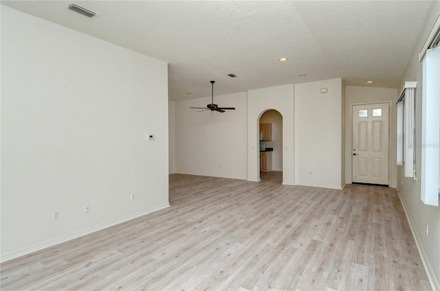 unfurnished living room featuring lofted ceiling, ceiling fan, light hardwood / wood-style floors, and a textured ceiling