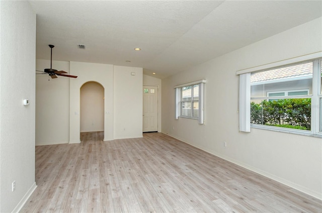 empty room featuring a textured ceiling, ceiling fan, light hardwood / wood-style flooring, and lofted ceiling