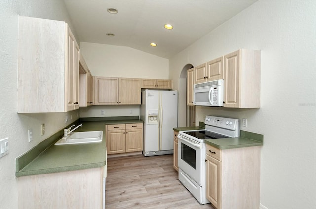 kitchen featuring sink, light brown cabinets, light hardwood / wood-style flooring, lofted ceiling, and white appliances