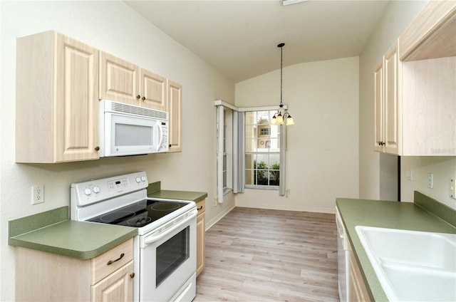 kitchen with white appliances, vaulted ceiling, decorative light fixtures, light hardwood / wood-style flooring, and a chandelier