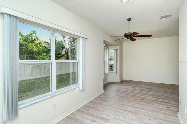 empty room with ceiling fan and light hardwood / wood-style flooring