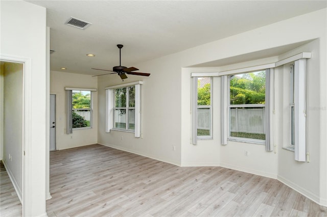 unfurnished room featuring light hardwood / wood-style flooring, ceiling fan, and a healthy amount of sunlight