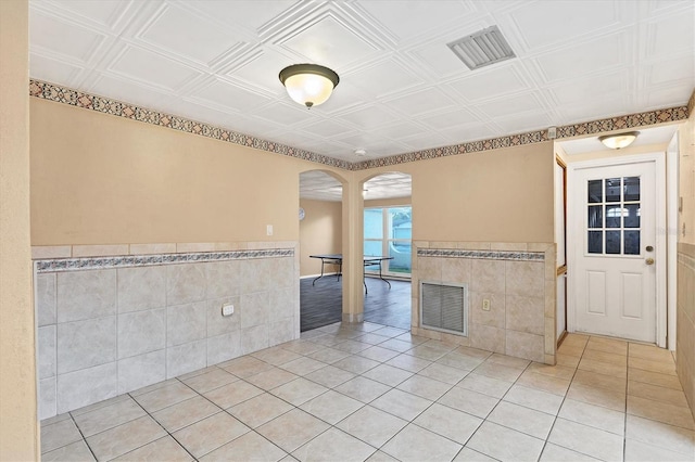 spare room featuring tile patterned flooring and tile walls