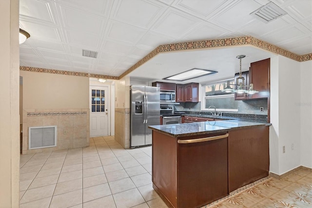 kitchen featuring sink, stainless steel appliances, kitchen peninsula, pendant lighting, and light tile patterned flooring