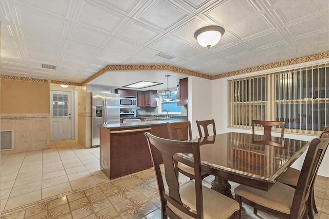 dining area featuring sink and light tile patterned floors