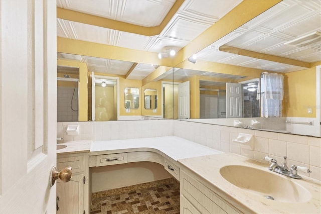 bathroom with backsplash, a shower, and vanity