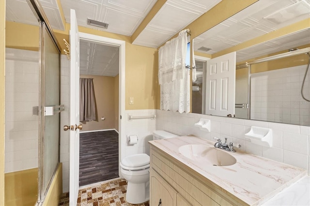 full bathroom featuring vanity, combined bath / shower with glass door, toilet, tile walls, and wood-type flooring