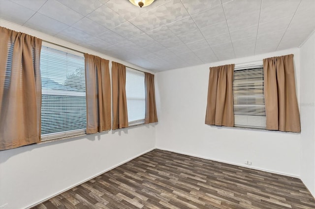 unfurnished room with dark wood-type flooring