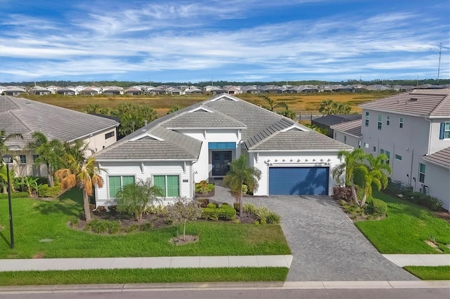 view of front of home with a front yard and a garage