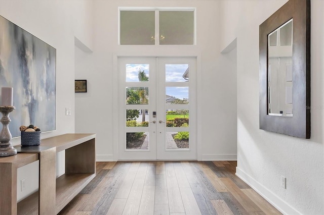 foyer entrance featuring french doors and light hardwood / wood-style floors