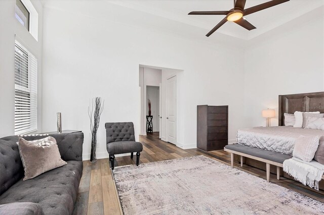 bedroom featuring a high ceiling, hardwood / wood-style flooring, and ceiling fan