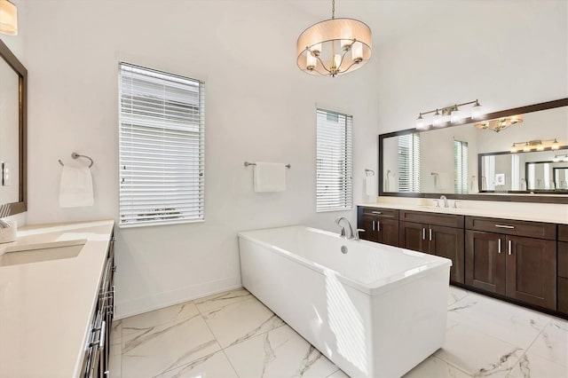 bathroom with a washtub, vanity, and an inviting chandelier