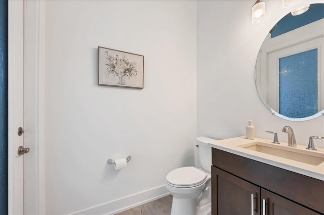 bathroom with hardwood / wood-style flooring, vanity, and toilet