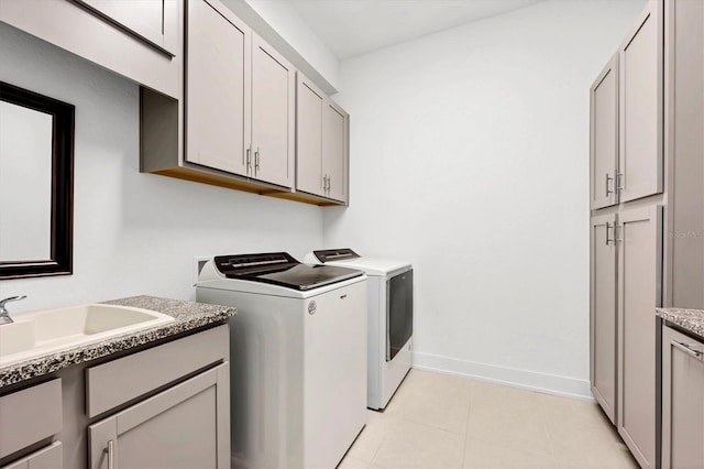 clothes washing area with cabinets, separate washer and dryer, sink, and light tile patterned floors