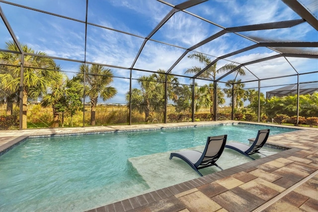 view of pool with glass enclosure and a patio area