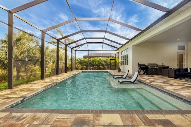 view of pool with glass enclosure, a patio, and grilling area